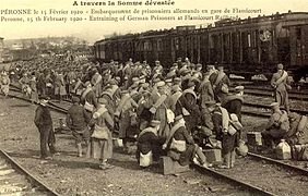 Carte postale ancienne montrant l'embarquement de prisonniers de guerre allemands en gare de Péronne - Flamicourt.