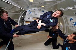 Hawking, without his wheelchair, floating weightless in the air inside a plane