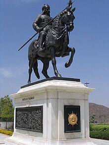 dark-coloured equestrian statue on a marble plinth