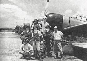 Photo noir et blanc d'un groupe de pilotes devant des avions.