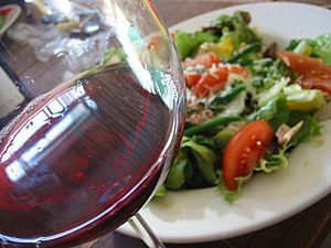 A glass of Beaujolais red wine with salad as b...