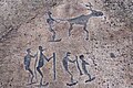 A petroglyph depicting 5 skiers and a reindeer