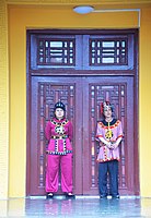שני עובדי המקום בתלבושת מסורתית לפני שער הכניסה לארמון צ'נגיון