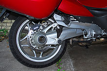  Closeup picture of the swingarm, rear wheel and rear brakes on a red BMW R1200RT motorcycle