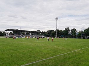 Hauptspielfeld mit Tribüne und Flutlichtanlage