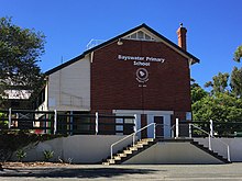 Photograph of Bayswater Primary School, a white painted wood and red brick building