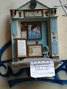 Photographie en couleurs. Autel en bois de couleur bleu ciel commune à l'Argentine et à Naples, accroché dans un mur des rues de Naples.