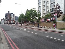 The site of the attack in Wellington Street, with floral tributes and flags, 30 May 2013 Drummer Lee Rigby flowers at Woolwich on the 30 May 2013.jpeg