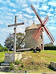 Le moulin à vent des Bénédictins aussi appelé moulin de Buglais, et le calvaire à Lancieux. L’ancien arbre moteur, déposé et remplacé lors de la restauration terminée au début de l’été 2023, est désormais posé au sol à côté du moulin.