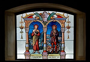Házaspárok mintája a Mária mennybemenetele plébániatemplom ólomüveg ablakán. Az ablak két szentet ábrázol, Boldog Torribia Máriát és Földműves Szent Izidort, akik házastársak voltak (Nesselwängle, Ausztria)
