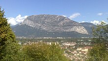 Versant en croupe arrondie d'une montagne dominant une vallée.