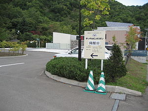 札幌市のアイヌ文化交流センターの案内看板。サッポロピㇼカコタンというアイヌ語が片仮名で併記されている。（「札幌の美しい村」という意味であり、「小書き片仮名の "リ"」が用いられている。）