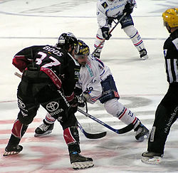 Rico Fata (valkoinen paita) DEL-joukkue Adler Mannheimin paidassa aloituksessa Hannover Scorpionsin Tino Boosia vastaan kaudella 2007–2008.