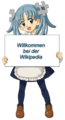 Википе-тан с табличкой (на немецком языке) «Добро пожаловать в Википедию»