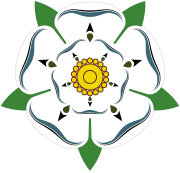 This is the White Rose of York, a white heraldic rose, which is the symbol of the House of York. Traditionally the origins of the emblem are said to go back to Edmund of Langley in the 14th century, the first Duke of York and the founder of the House of York as a Cadet branch of the then ruling House of Plantagenet.[22] The actual symbolism behind the rose has religious connotations as it represents the Virgin Mary, who was often called the Mystical Rose of Heaven.[22][23]