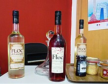 Trois bouteilles de floc exposées sur une table.