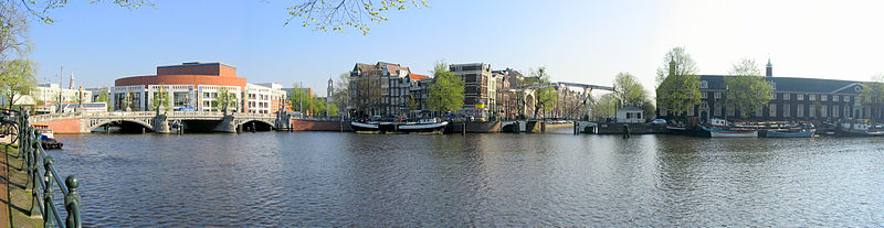 The Amstel river in Amsterdam, panoramic view showing the Stopera and Blauwbrug (left) and Amstelhof (right), which houses the Hermitage Amsterdam museum