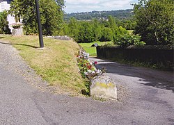 La côte de la Fontaine, l'abreuvoir fleuri et le lavoir à l'arrière-plan.