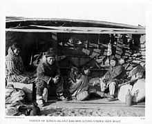 Famille assise à l'abri d'un oumiak (Alaska, environ 1904).