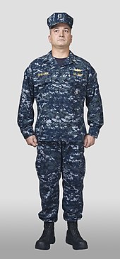 A male navy officer wearing the NWU Type I (2008); the uniform was retired in 2019. LT Opalenik, USN.jpg