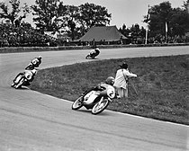 Hugh Anderson aan de leiding van de 50cc-race in Assen (1963), herkenbaar aan de Kiwi op zijn helm. Ernst Degner rijdt nog als vierde, maar zou zijn enige 50cc-overwinning van het seizoen scoren.