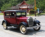 Sedan Ford Modelo A Tudor 1928 - mostrado para comparação, com corpo mais largo e portas curvas