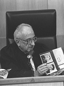 אב בית הדין דב לוין מעיין בתמונות במהלך משפטו של ג'ון דמיאניוק בירושלים, 1987