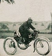 Photo d'un homme conduisant un cycle motorisé à trois roues.