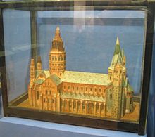 Papírový model sakrální stavby ve vitríně.