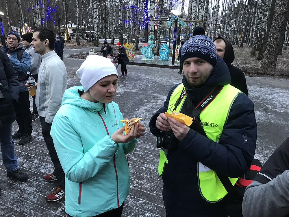 Волонтёры едят праздничный паркран-торт