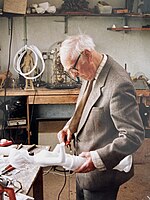 Elderly man carving a white sculpture