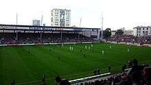 Photographie d'un stade plein où se déroule un match de football.