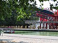 Un groupe de cyclistes passe sous une passerelle, le long du Canal de l'Ourcq, à Paris.