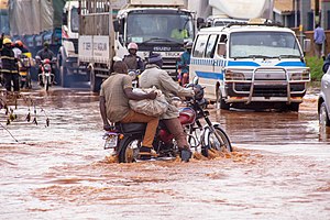 Ein Motorradfahrer auf einer überschwemmten Straße in Kampala