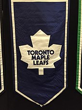 A banner featuring an old Maple Leaf logo, featuring an eleven-pointed white maple leaf on a blue background.