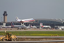 A plane lands as other planes are parked in the background