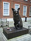 Statue en bronze d'un chat assis sur un livre