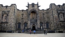 The entrance and facade of the Scottish National War Memorial. The five niche statues are (left to right) 'Courage', 'Peace', 'Survival of the Spirit' (above the porch), 'Mercy' and 'Justice'. Facade of the Scottish National War Memorial, Edinburgh Castle, Scotland, UK.jpg