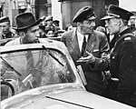 הצלם ג'וליאן בריאן (בתוך הרכב) נחקר על ידי שוטר פולני, תחת חשד של ריגול לטובת גרמניה במהלך צילומים בורשה.
