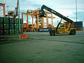 Reach Stacker in operation at Kuantan Port. Rubber Tyred Gantry visible at the background