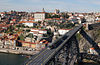 Metal bridge across a river and city centre built on a hillside