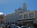 Front facade has balustrade parapet and cornice. Hood moulds plus panels to first floor windows. Plastered ashlar below. Fine 1880s facade. Complex building behind. This building is unique in structure and was used by Henry Carter Galpin, watchmaker and jeweller, as a home and business premises soon after his arrival in Grahamstown in 1849. In 1880 Galpin installed a camera obscura in the turret of the building. Current use: Commercial – Observatory. This building is unique in structure and was used by Henry Carter Galpin, watchmaker and jeweller, as a home and business premises soon after his arrival in Grahamstown in 1849. In 1880 Galpin installed a camera obscura in the turret of the building.