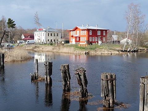 Тот же ракурс и вид на здание школы в 2021 году. На переднем плане остатки сооружения, которое вместе с каменным мостом, расположенным рядом, составляло «Северный щитовой гранитный водоспуск»