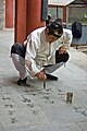 Даосистський чернець практикує китайську каліграфію з водою на камені
