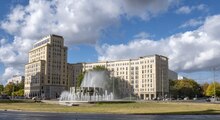 Foto distante del gran edificio blanco de varios pisos, con árboles en el frente Strausberger Platz, Berlín