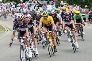 A group of cyclists, with one wearing a yellow jersey