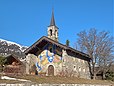 La Chapelle de Mussillon Notre-Dame-des-Neiges à Méribel, au cœur du domaine des Trois-Vallées en Savoie. Afin de suspendre des pots de fleurs de chaque côté de la façade, sont fixés des potences métalliques réalisées par la société Ferodem.