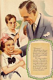 A 1938 propaganda of the Estado Novo (New State) regime depicting Brazilian president Getulio Vargas flanked by children. The text reads: "Children! Learning, at home and in school, the cult of the Fatherland, you will bring all chances of success to life. Only love builds and, strongly loving Brazil, you will lead it to the greatest of destinies among Nations, fulfilling the desires of exaltation nestled in every Brazilian heart." Propaganda do Estado Novo (Brasil).jpg