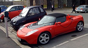 A Tesla Roadster and other electric cars parke...