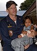ВМС США 060613-N-8391L-098 Корабль-госпиталь Управления морских перевозок США USNS Mercy (T-AH 19), командир лечебного учреждения, капитан Джозеф Мур, держит на руках маленькую девочку, ожидающую медицинской эвакуации.